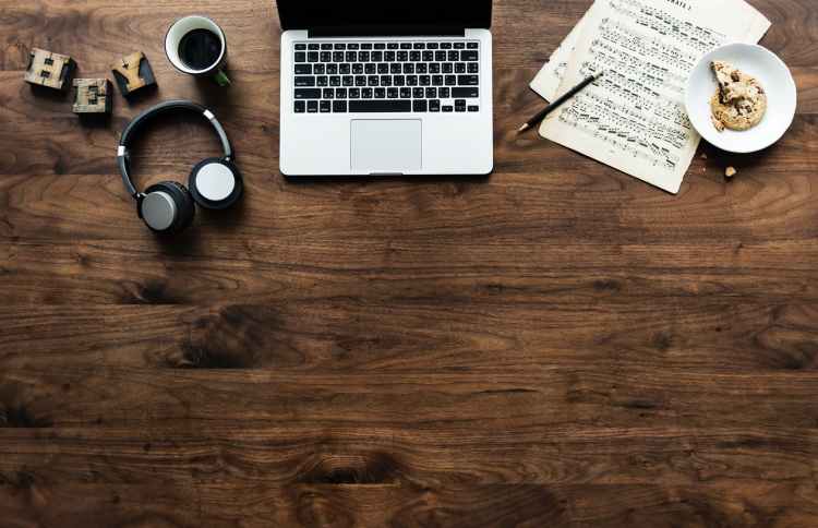 macbook near wireless headphones mug and saucer